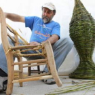 Un artesano hace una demotración de la elaboración de una silla de paja.