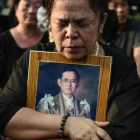 Una mujer llora la muerte del rey Bhumibol de Tailandia frente al Gran Palacio de Bangkok.