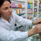 Una farmacéutica de León coloca una de las chapas