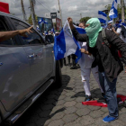 Manifestantes con banderas de Nicaragua participan en una marcha llamada La Marcha de las Banderas  contra el gobierno del presidente Daniel Ortega.