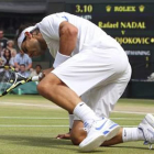 Rafa Nadal con gesto de resignación cae en una acción del juego ante el serbio Djokovic.