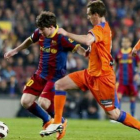 El delantero argentino del Barça, Messi, trata de zafarse del jugador del Getafe Borja.