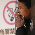 Un hombre fuma junto a un cartel que prohíbe fumar, en un centro comercial de Shangái, el pasado 10 de enero.