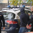 Efectivos de la Policía Nacional conducen a uno de los quince detenidos en la reyerta en Madrid producida entre radicales del Deportivo de La Coruña y del Atlético de Madrid