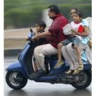 Una familia se desplaza en una moto en un barrio de Nueva Delhi