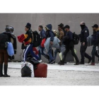 La policía griega escolta a inmigrantes en el exterior de un estadio en el sur de Atenas.