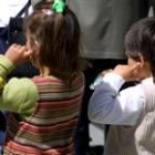 Dos niños se tapan los oídos para protegerse del ruido de unos petardos en unas protestas