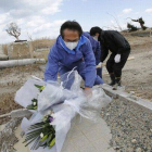 Un grupo de hombres deposita flores en Namie, en la prefectura de Fukushima.