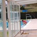 Una empleada de la piscina comprueba la temperatura del agua de la piscina de Trobajo