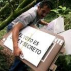 Un agentes electoral lleva por la selva las urnas y pancartas electorales
