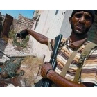 Un combatiente rebelde muestra los cuerpos de dos soldados gadafistas muertos en Zawiya.