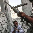 Un hombre con un arma incautada el Estado Islámico en Kobane.