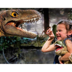 Una niña juega con uno de los animales de la exposición ‘Dinosaurs Tour’, que recalará en León durante dos días. DL