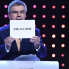 El presidente del Comité Olímpico Internacional, Thomas Bach, muestra el nombre de ciudad escogida como sede de los JJOO de invierno de 2022