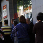 Un grupo de ciudadanos esperan ante una oficina de empleo en Madrid, el pasado mayo.