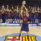 Navarro, capitán del Barcelona, levanta la copa que acredita a su equipo como campeón liguero.
