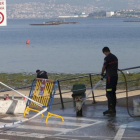 Operarios limpian el lugar donde el joven fue asesinado, en la playa de Arealonga de Chapela, en Redondela, Vigo.