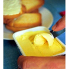 Una persona se prepara una tostada con mantequilla.