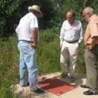 El geólogo, acompañado por el alcalde y un concejal, ante el pozo de los regantes de Nistal