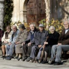 Varios ancianos toman el sol en unos bancos de Olmeda de la Cuesta, Cuenca.