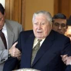 Dos ayudantes de Pinochet le ayudan a caminar a la puerta de su casa de Santiago de Chile