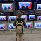 Un niño contempla las televisiones de un escaparate.