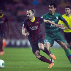 Iniesta, que salió como titular conduce el balón superando la defensa del levantinista Ríos.