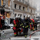 Los bomberos trasladan a una herida en la explosión en una panadería en París, este sábado.