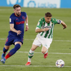 Joaquín Sánchez conduce el balón ante el mexicano del Atlético de Madrid Héctor Herrera. JOSE M. V.