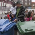 El alcalde de San Andrés le muestra a un niño en qué cubo se tira el papel