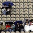 Los espectadores se cubren con paraguas en la pista Suzanne Lenglen