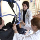 Dos sanitarios ayudan a Iván a hacer sus ejercicios en el Centro de Referencia Estatal de Burgos.