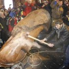 Varias personas protestan golpeando la estatua del líder Vladimir Lenin.