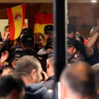 Policías nacionales, en la entrada del hotel de Pineda en el que están alojados, se enfrentan a los ciudadanos que protestan fuera.