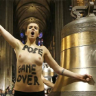 Una de las feministas lanza sus consignas junto a una de las campanas de la catedral de Notre-Dame de París.