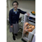 Elisa muestra su nevera, donde conserva los alimentos básicos