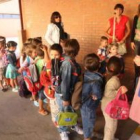 Un grupo de niños espera para entrar a clase el primer día del curso escolar.