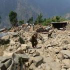 Nepalís caminan entre escombros de casas en la localidad de Ungul, a 60 kilómetros de Katmandú, el lunes