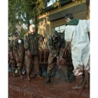 Soldados hacen fila para ser limpiados tras recoger lodo.