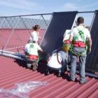 Alumnos del taller colocan placas solares en el polideportivo.