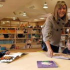 Unos niños disfrutan de la lectura de cuentos en la zona infantil de la biblioteca del Centro Cívico