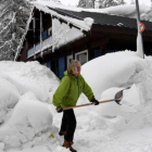 Una mujer limpia la nieve de los accesos a su casa en Val dIsere, en los Alpes franceses.