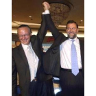 Mariano Rajoy levanta la mano de Josep Piqué en el acto celebrado ayer