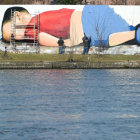 Enorme grafiti de Aylán en la orilla del río que cruza Fráncfort.
