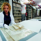 Eva Merino, directora del Archivo Histórico Provincial de León, mostrando unos documentos en el depósito del archivo.