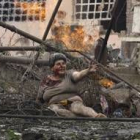 Una mujer herida entre los escombros de un edificio bombardeado