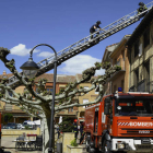 Los bomberos de León, sobre la cubierta del edificio, comprobando la misma tras el incendio. ACACIO