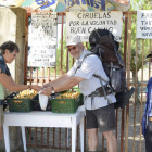 Dos peregrinos aprovechan la oferta de Carlos Rivero (derecha), que ofrece su mercancía a las puerta de su finca.