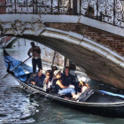 Unos turistas pasean en góndola por Venecia.