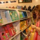 Una mujer observa los libros de texto expuestos en unos grandes almacenes leoneses